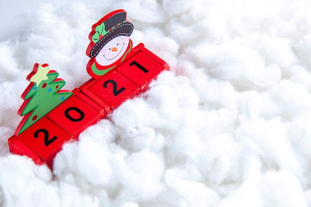 Blocchi di legno vista dal basso con piccolo pupazzo di neve e albero di natale su sfondo bianco