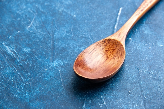Bottom view wooden spoon on blue surface copy place