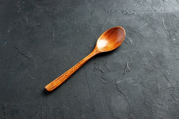 Free photo bottom view wooden spoon on dark surface with free space stock photo