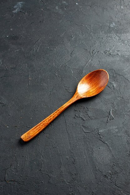 Bottom view wooden spoon on dark surface with free space