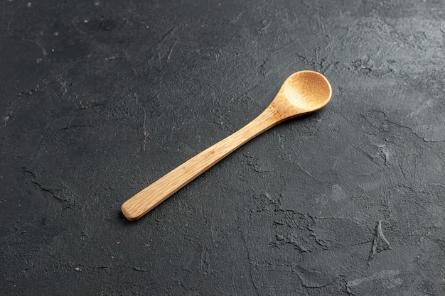 Bottom view wooden spoon on dark table with free space