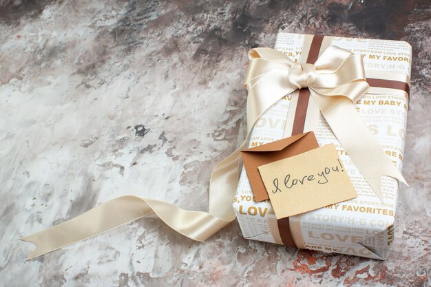 Bottom view wrapped gift i love you written on letter on table