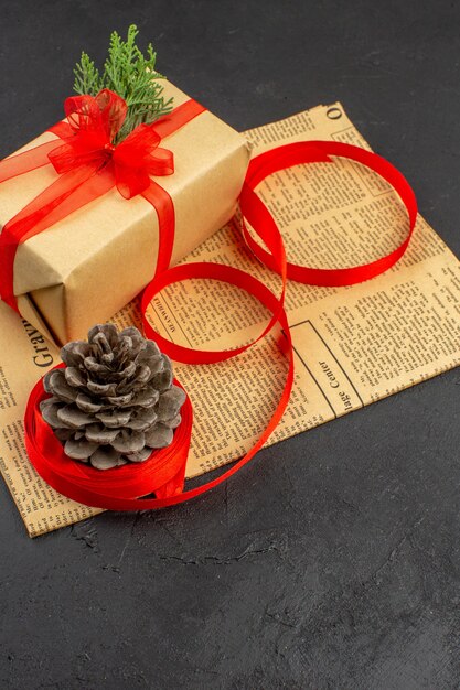 暗い背景の新聞の茶色の紙の枝モミリボンの底面図クリスマスギフト