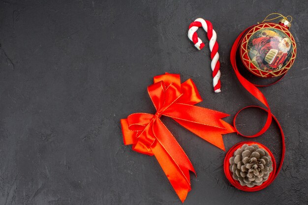 Bottom view xmas gifts in brown paper ribbon xmas tree toy on newspaper on dark background