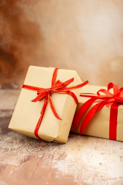 Bottom view xmas gifts in brown paper ribbon xmas tree toy on newspaper on dark background