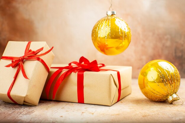 Bottom view xmas gifts in brown paper ribbon xmas tree toy on newspaper on dark background