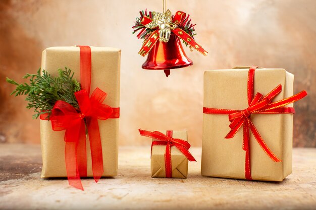 Рождественские подарки в коричневой бумажной ленте, рождественские елочные игрушки на газете на бежевом фоне, вид снизу