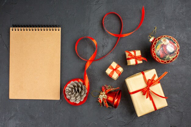 Bottom view xmas gifts in brown paper ribbon xmas tree toys on newspaper on beige background