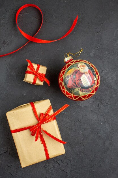 Bottom view xmas gifts in brown paper ribbon xmas tree toys on newspaper on beige background