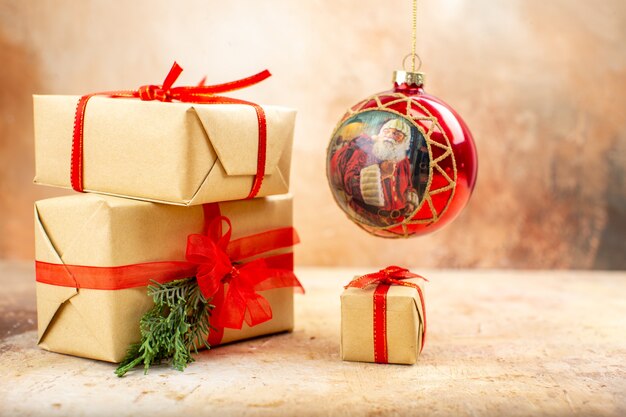 ベージュの新聞の茶色の紙のリボンのクリスマスツリーのおもちゃの底面図のクリスマスプレゼント