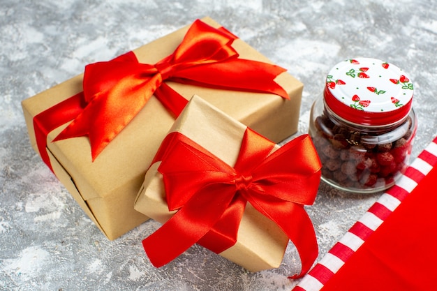 Bottom view xmas gifts tied with red ribbon cereal in jar on grey background