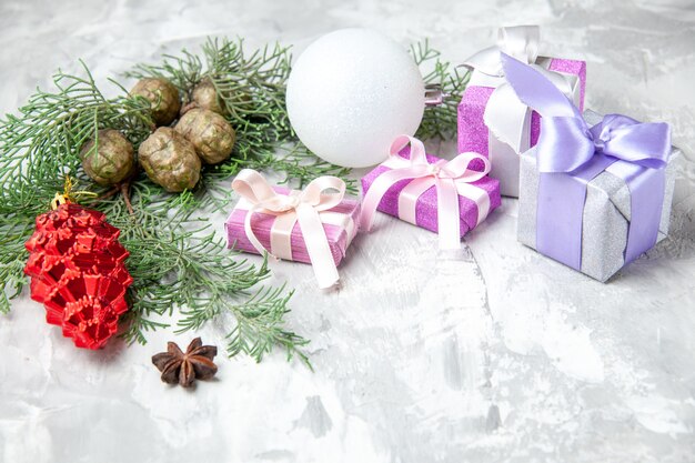 Вид снизу рождественские подарки елочные игрушки ветки сосны на сером фоне