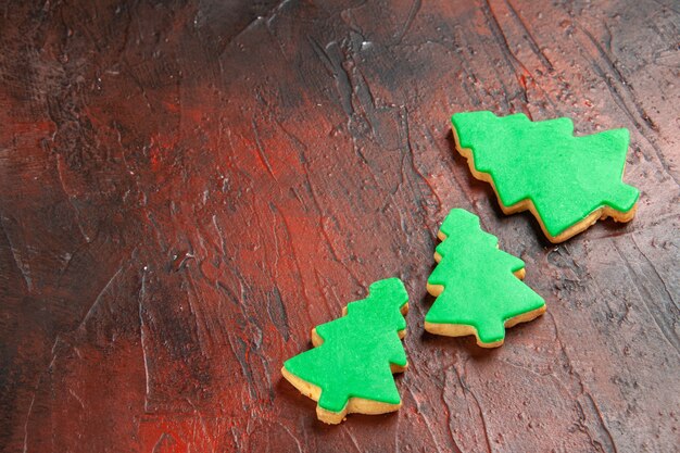 Bottom view xmas tree biscuits on dark red table free space