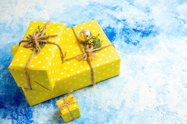 Bottom view yellow gifts tied with rope on blue table free space