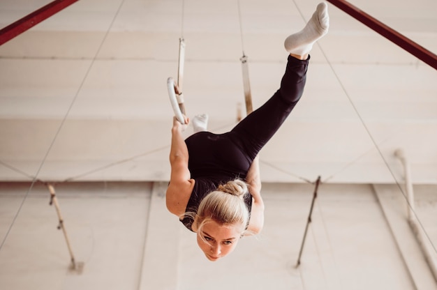 Bottom view young woman training on gymnastics rings