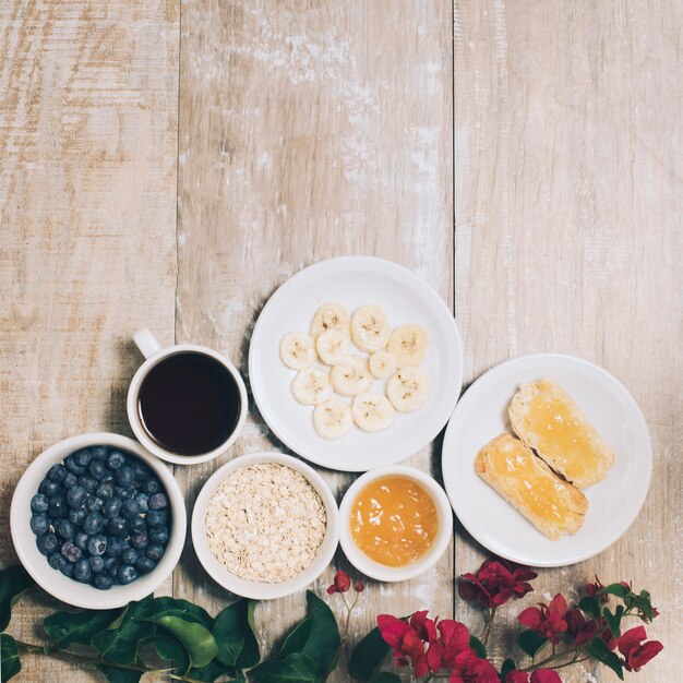 Bougainvillea flowers with breakfast and coffee on plank