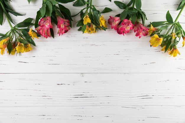 白い木製の織り目加工の背景にアルストロメリアの花の花束
