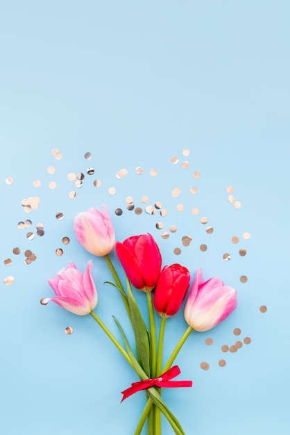 Bouquet of bright tulips and glittering confetti