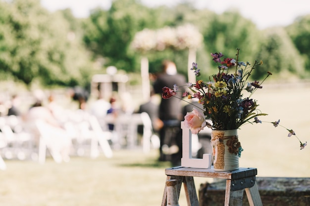 Bouquet of field flowers stands on the little chair