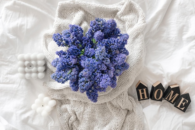 Foto gratuita un bouquet di candele di fiori e una parola decorativa casa in una vista dall'alto del letto bianco