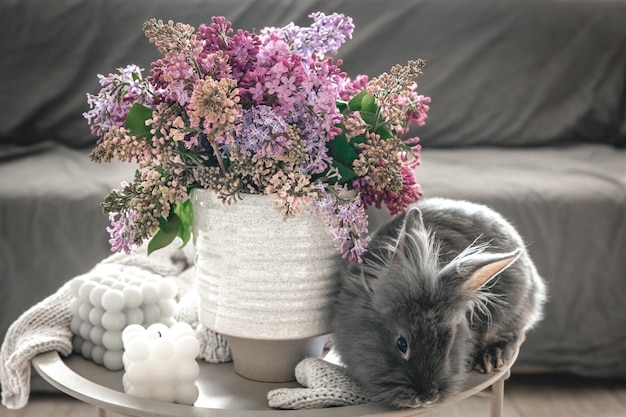 Free photo a bouquet of flowers a rabbit and candles on a blurred background