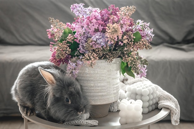 Free photo a bouquet of flowers a rabbit and candles on a blurred background