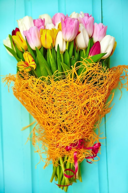 Bouquet di fiori di tulipano multicolori freschi sul vecchio tavolo di legno blu