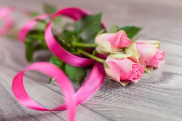 Bouquet of fresh roses on wood