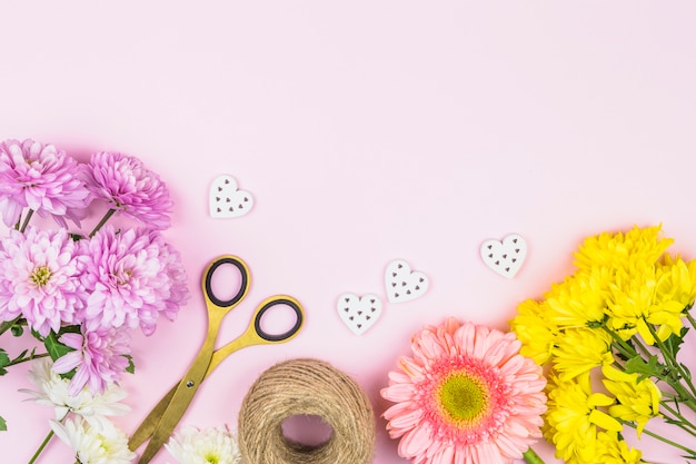 Бесплатное фото Букет из живых цветов возле ножниц и декоративных сердечек