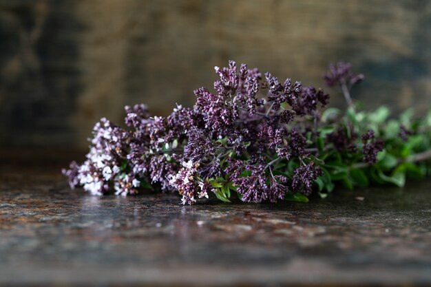A bouquet of oregano flowers on a wooden table. copy space