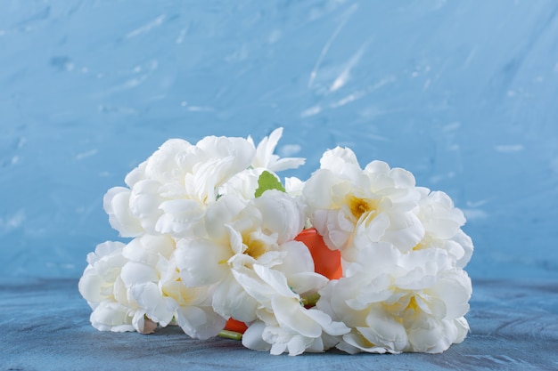 Bouquet Of Pale Flowers In An Orange Vase On Blue.