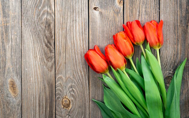 Bouquet of red tulips on a wooden background top view