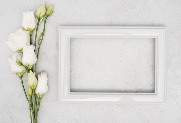 Free photo bouquet of roses and empty vintage frame