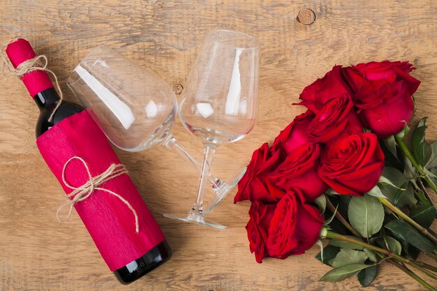 Bouquet of roses glasses and a bottle of wine