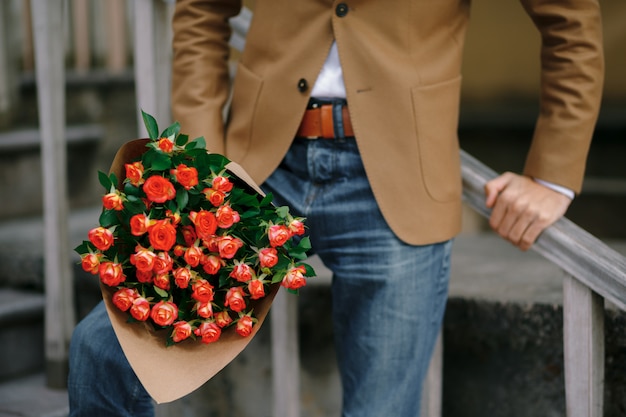 男性の手にバラの花束。