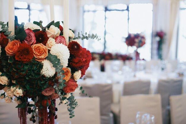 Bouquet of roses and pins stands on dinner table in restaurant 