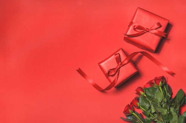 Bouquet of roses on a red background and a gifts