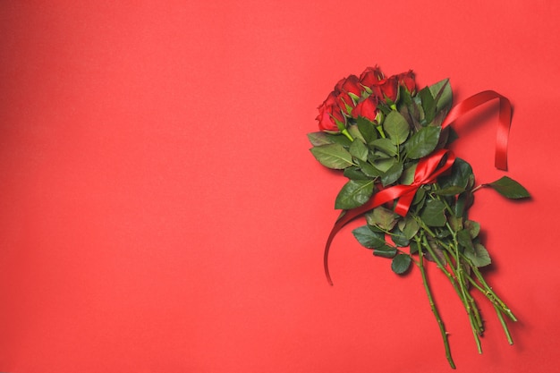 Foto gratuita bouquet di rose su fondo rosso