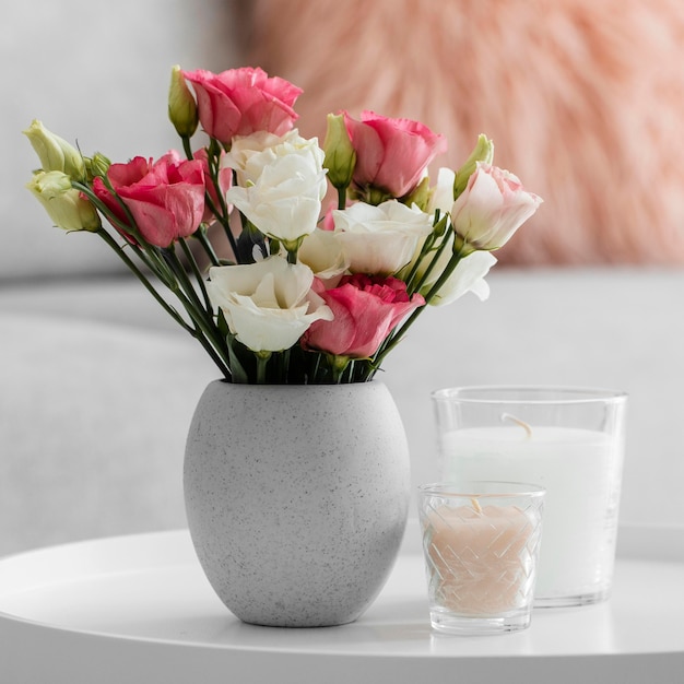 Bouquet of roses in a vase next to candles