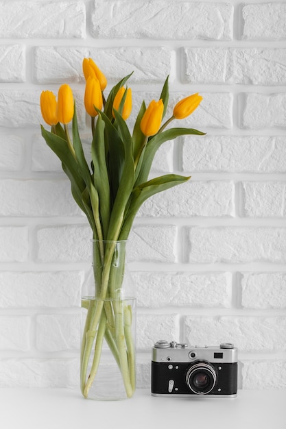 Букет тюльпанов в прозрачной вазе с фотоаппаратом