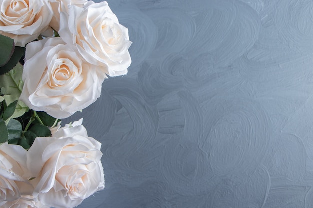 A bouquet of white flowers in a bucket, on the white table.