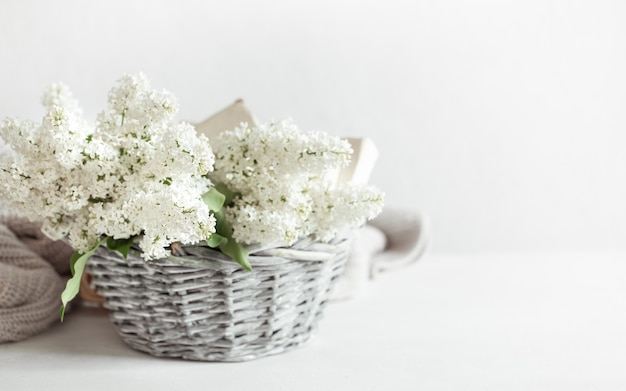 A bouquet of white lilac flowers in a decorative basket  