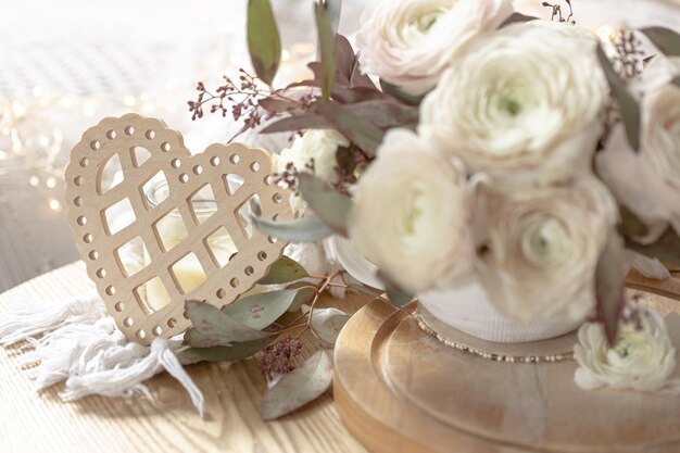 Bouquet of white ranunculus flowers on a blurred background with a heart