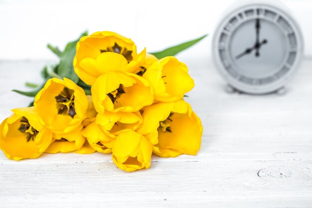 노란 튤립 꽃다발과 복고풍 시계
