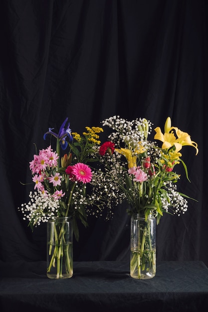 Бесплатное фото Букеты из ярких цветов в вазах с водой
