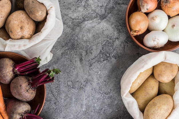 Bowl and bags with vegetables on table