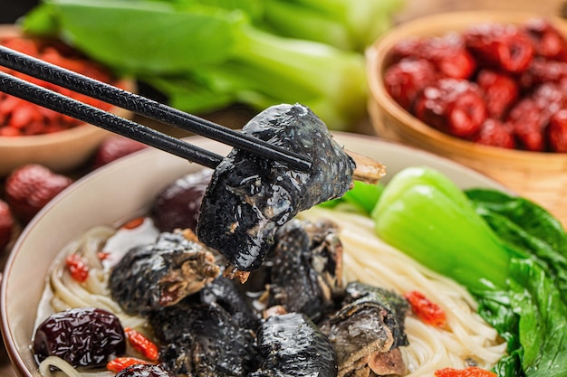 Free photo a bowl of black chicken noodles