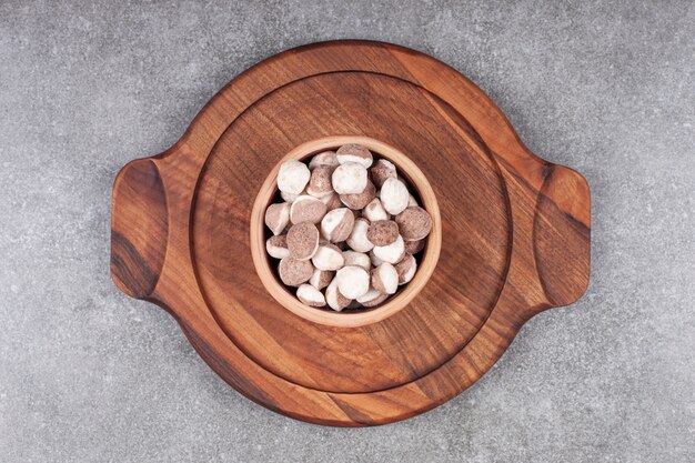 Free photo bowl of brown candies on wooden board