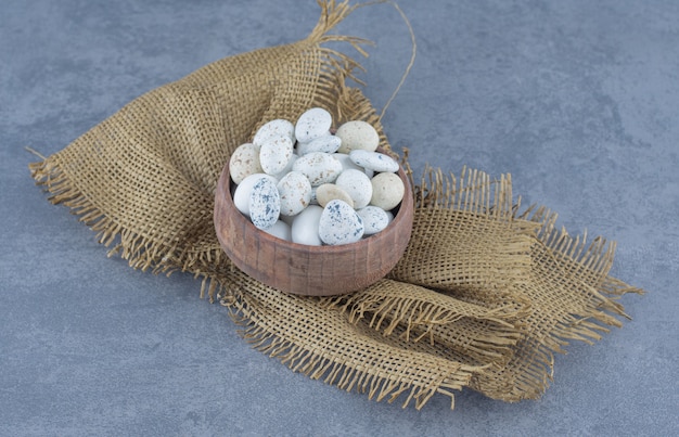 A bowl of candy on the towel, on the marble background. 