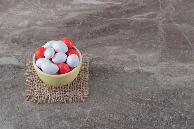 A bowl of candy on the trivet, on the marble surface